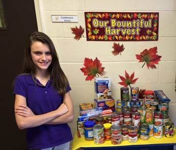 Maggie Roscher of C.F. Richards standing with some of the collected food.