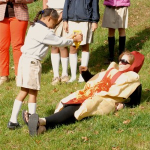 Kyra, a first grader, gleefully squirts mustard on her mother, Principal Jami Walker. 